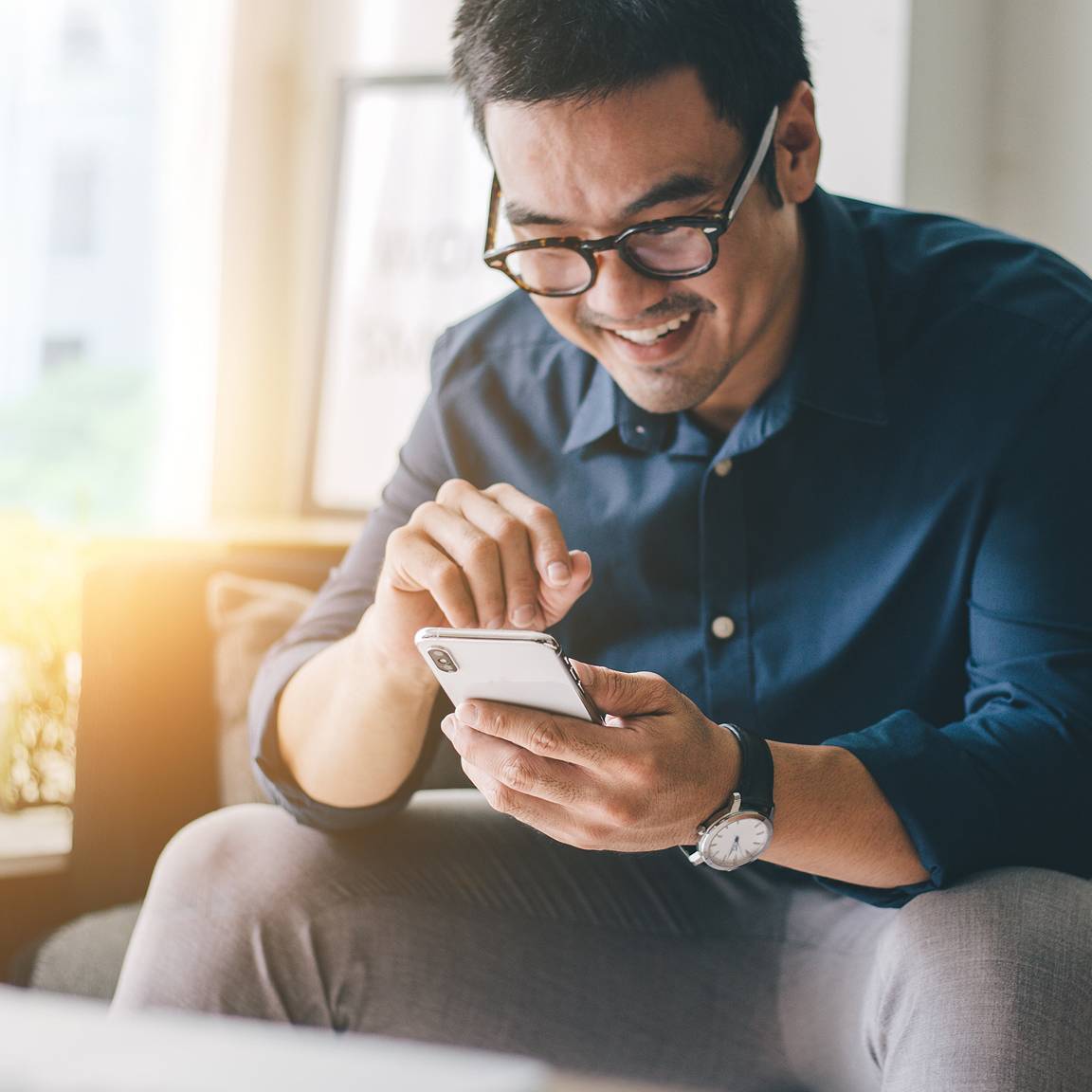 man sat on sofa using phone