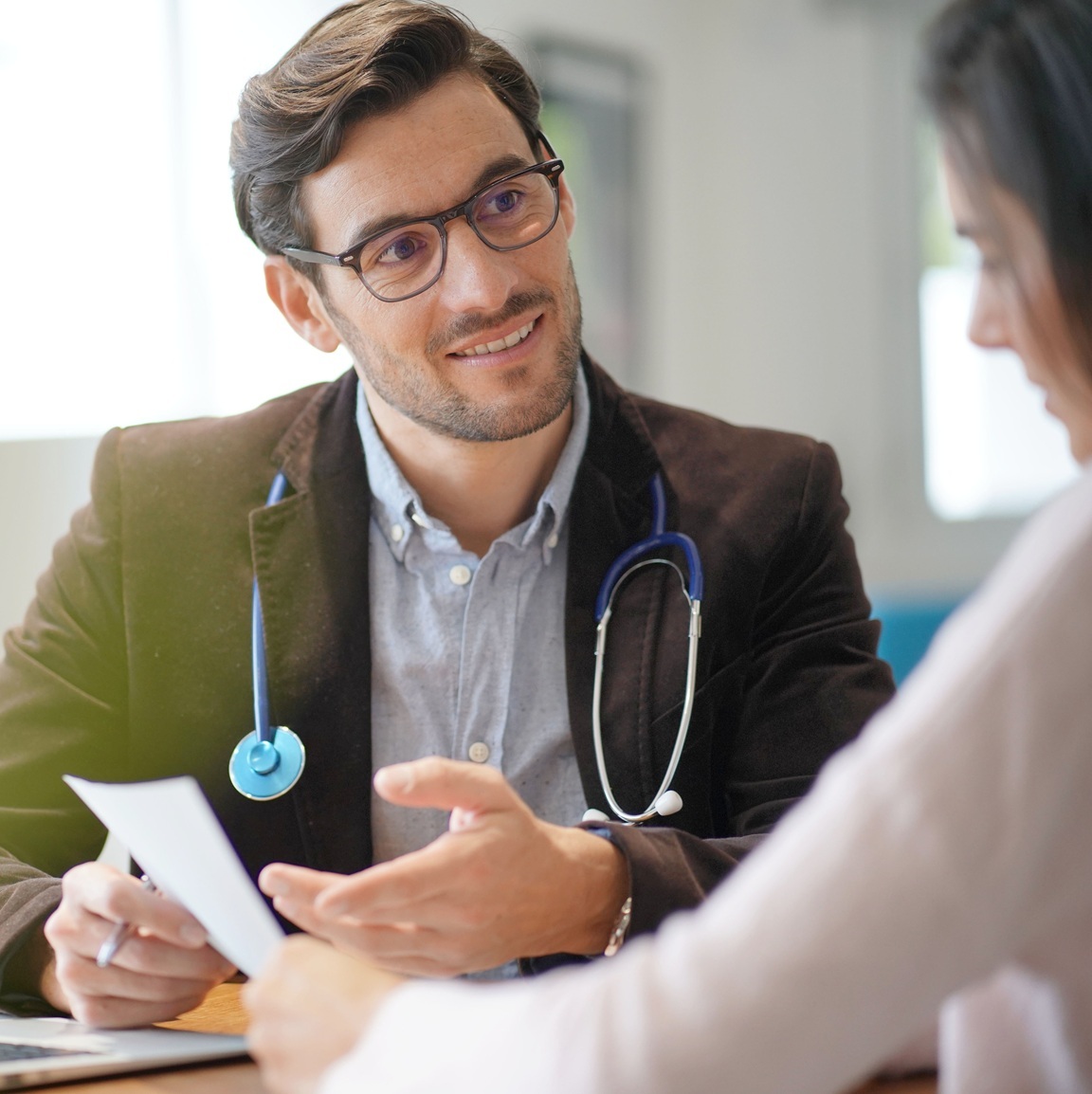 doctor holding documents talking to a patient