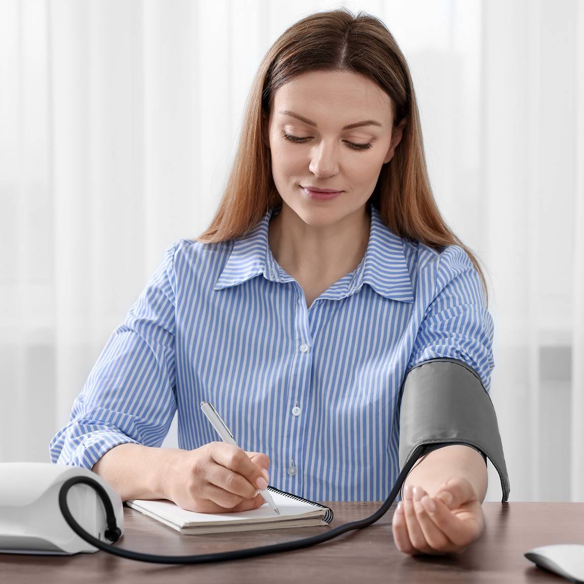 woman doing blood pressure test and taking notes