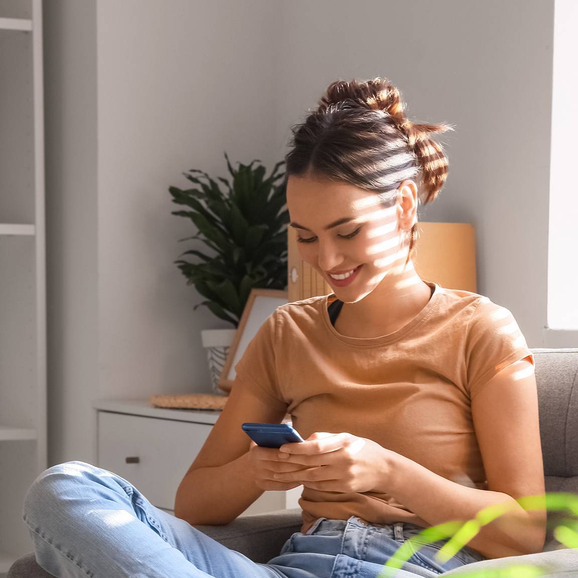 woman sat on chair using phone
