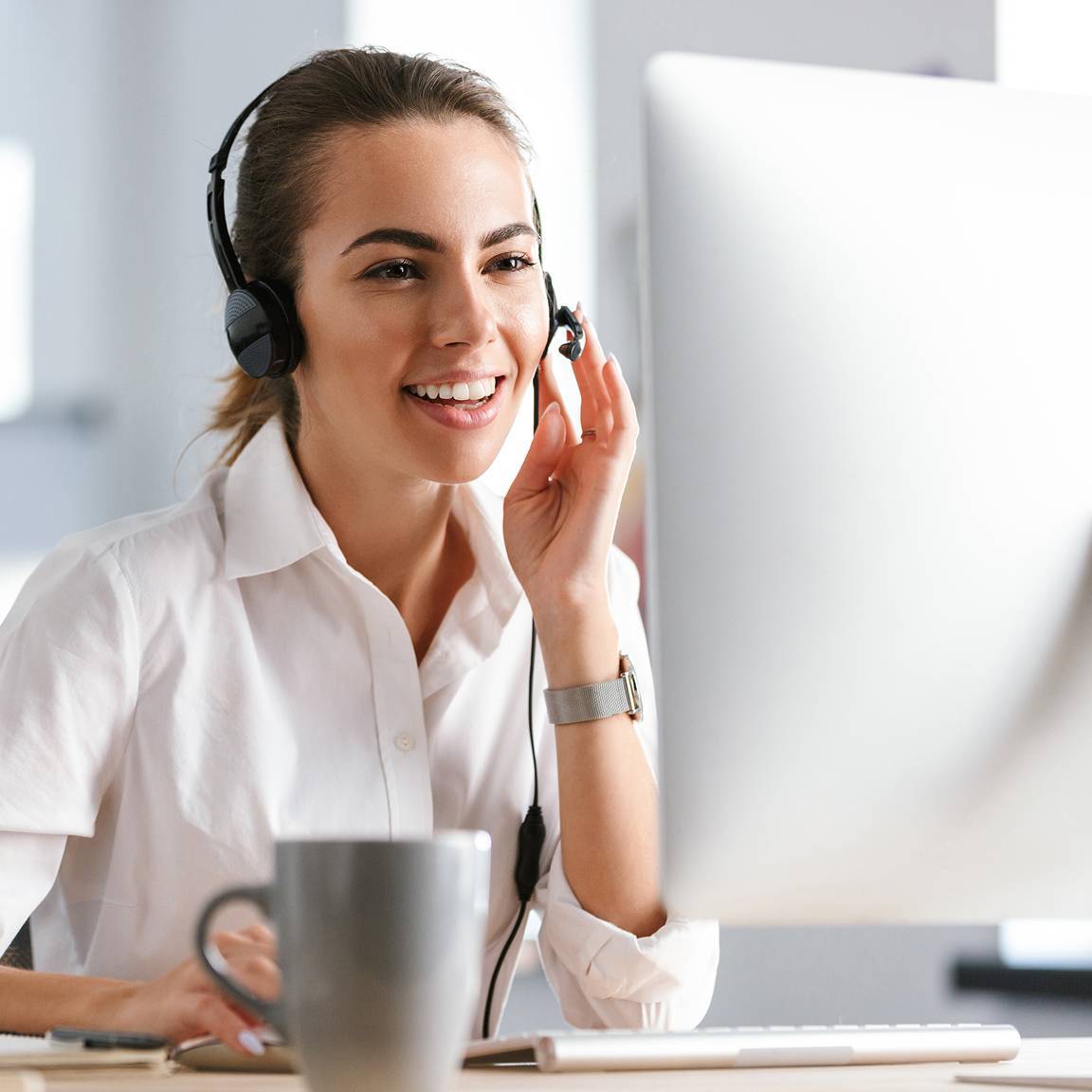 woman using headset looking at desktop monitor